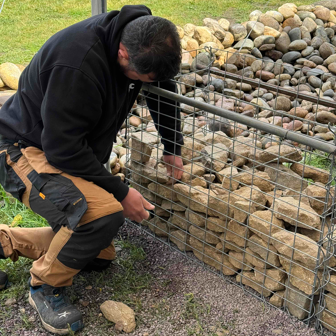 Účastník kurzu ručně skládá pohledovou stranu gabionu